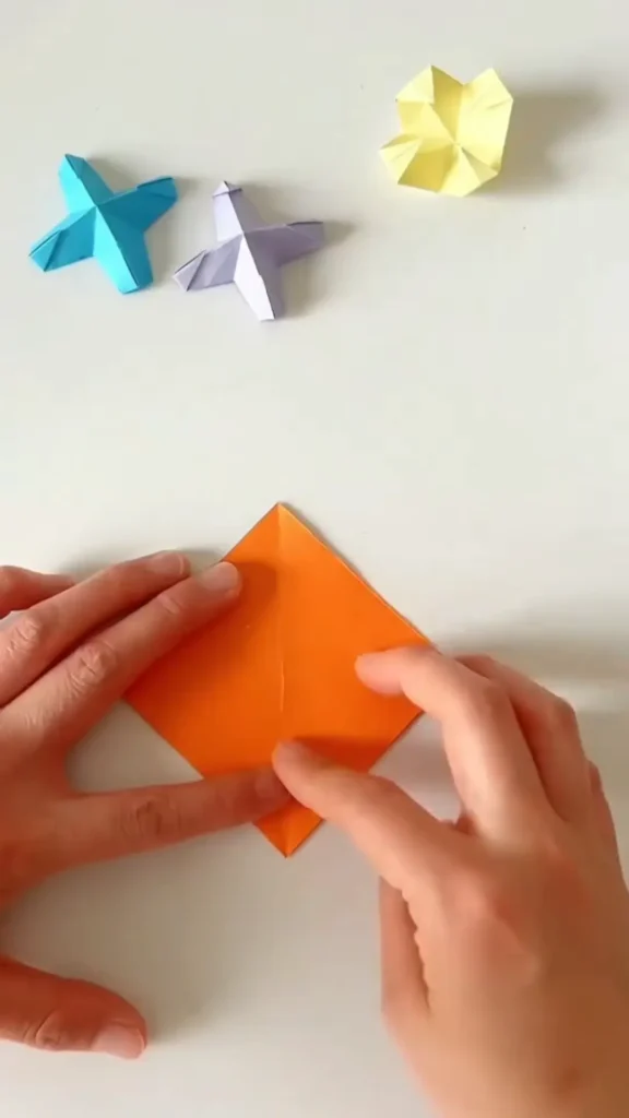 Folding square paper diagonally from corner to corner origami star step 1