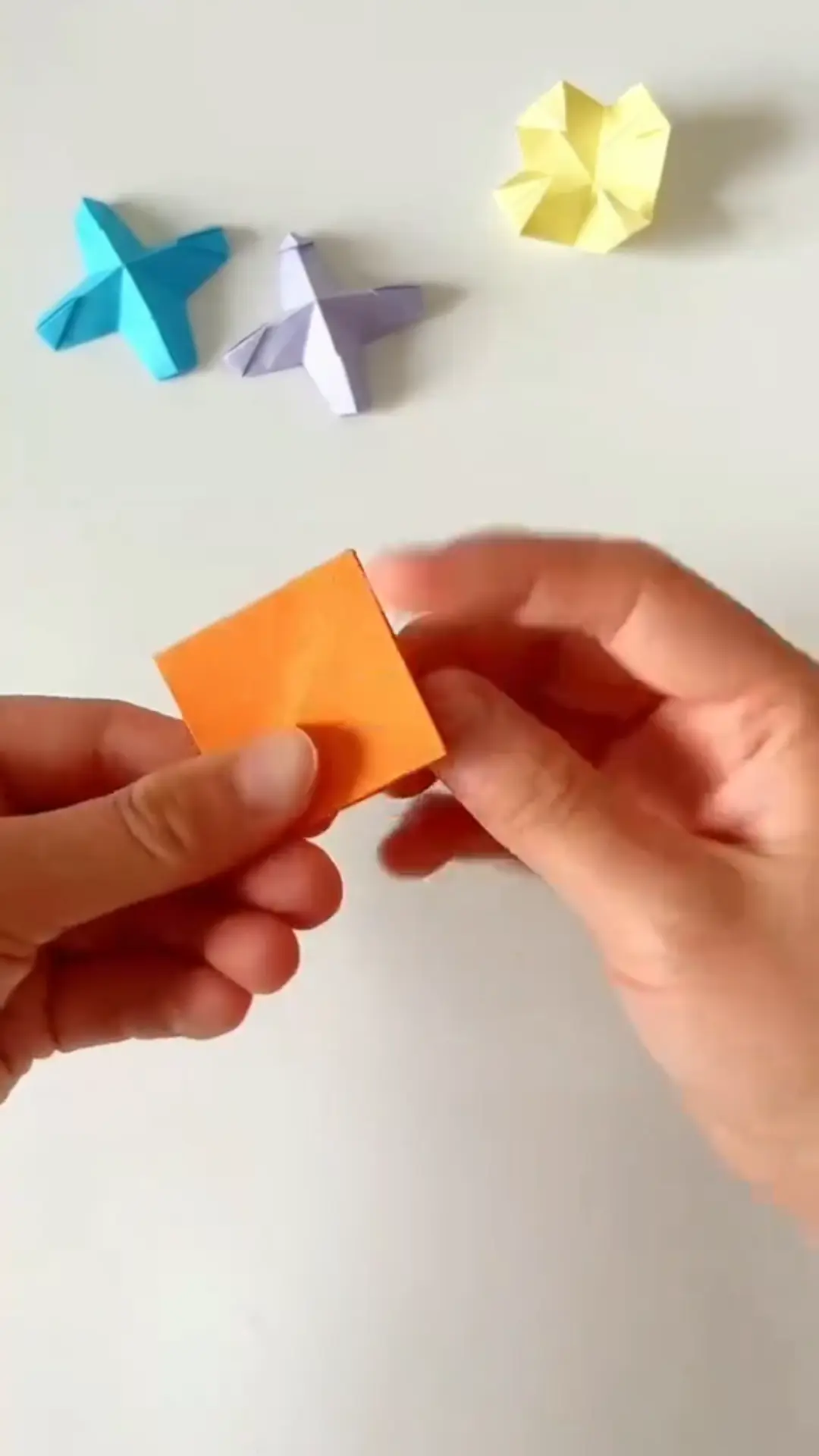 All four corners folded inward toward the center to form smaller square